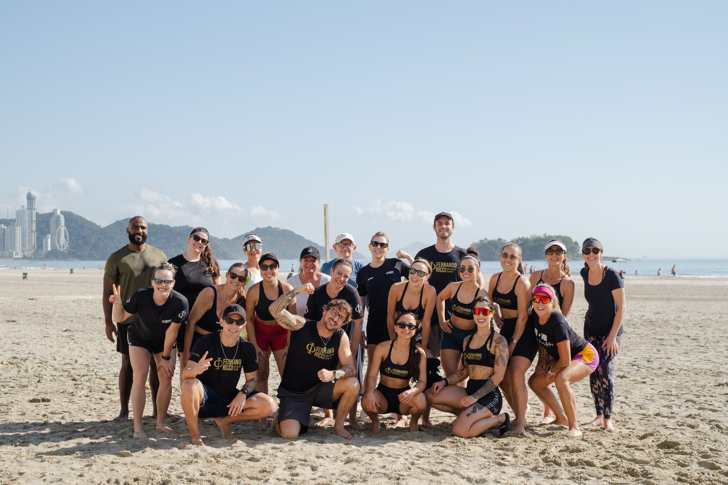Alunos do studio reunidos na Praia Central, com os prédios de Balneário Camboriú ao fundo