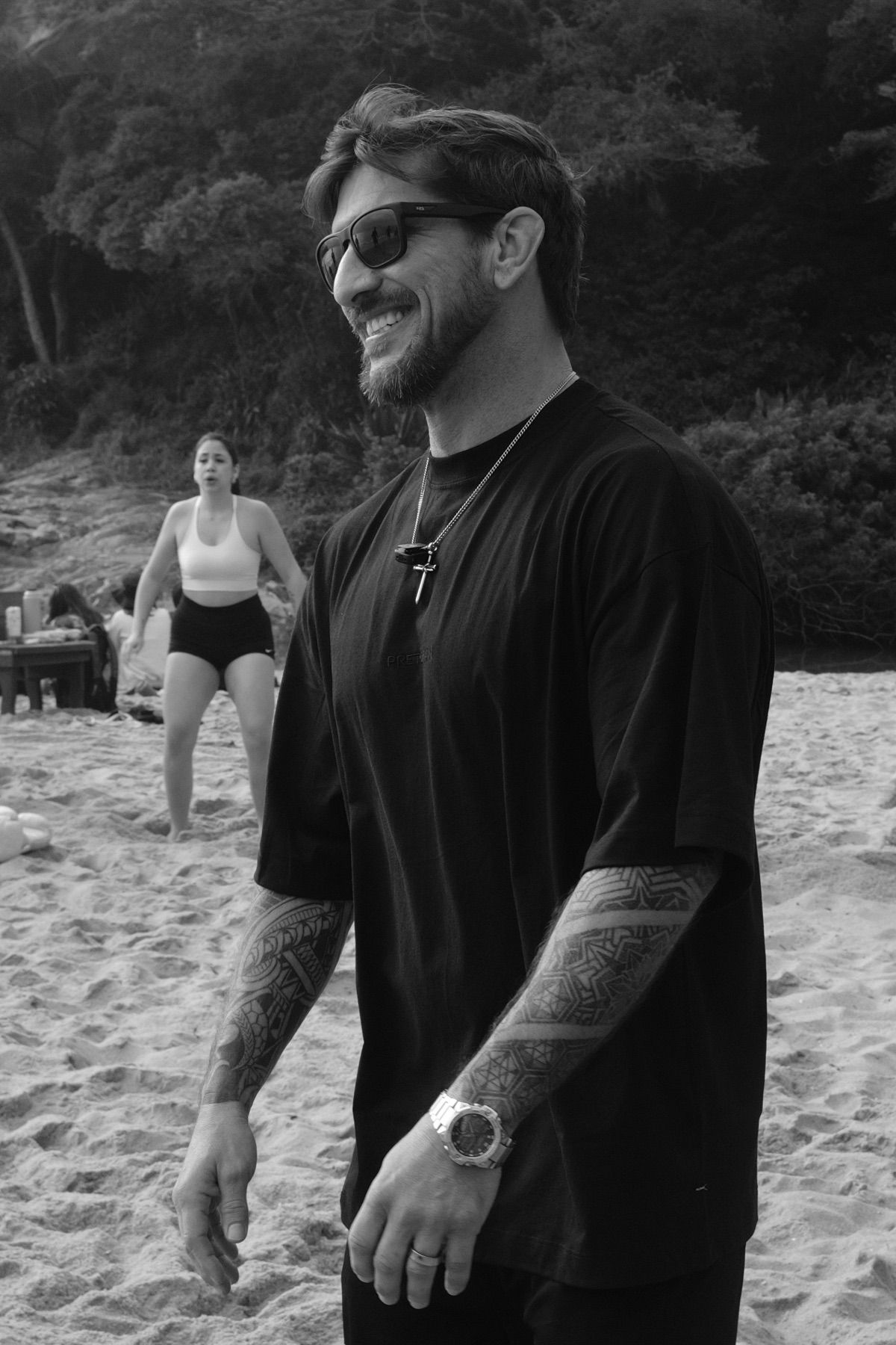 Fernando Ricci sorrindo na areia, em preto e branco